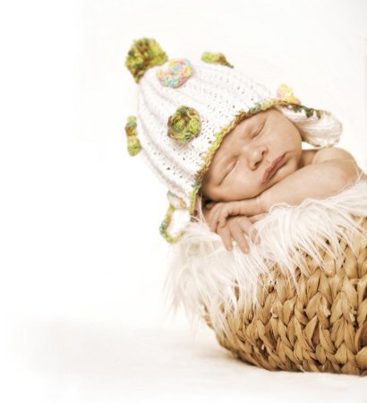 Baby mit Mütze im Korb